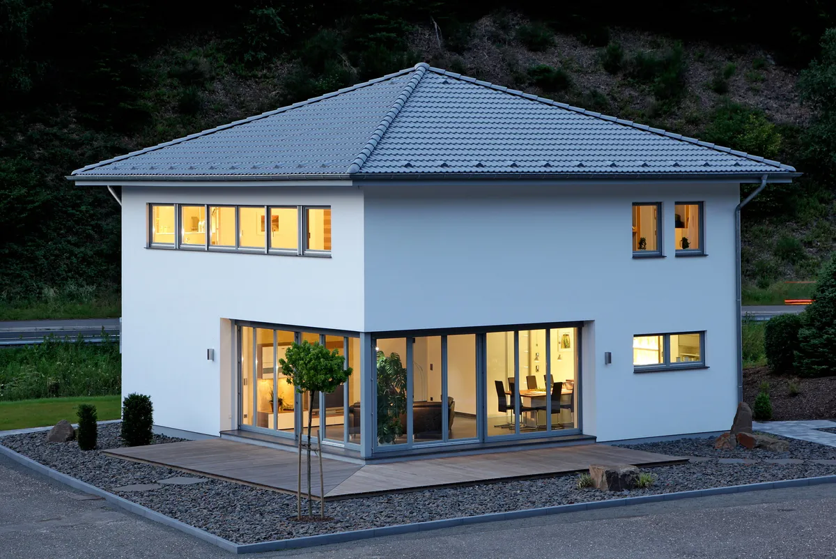 Straßenansicht einer Musterhaus Stadtvilla bei Dämmerung in Kuerten